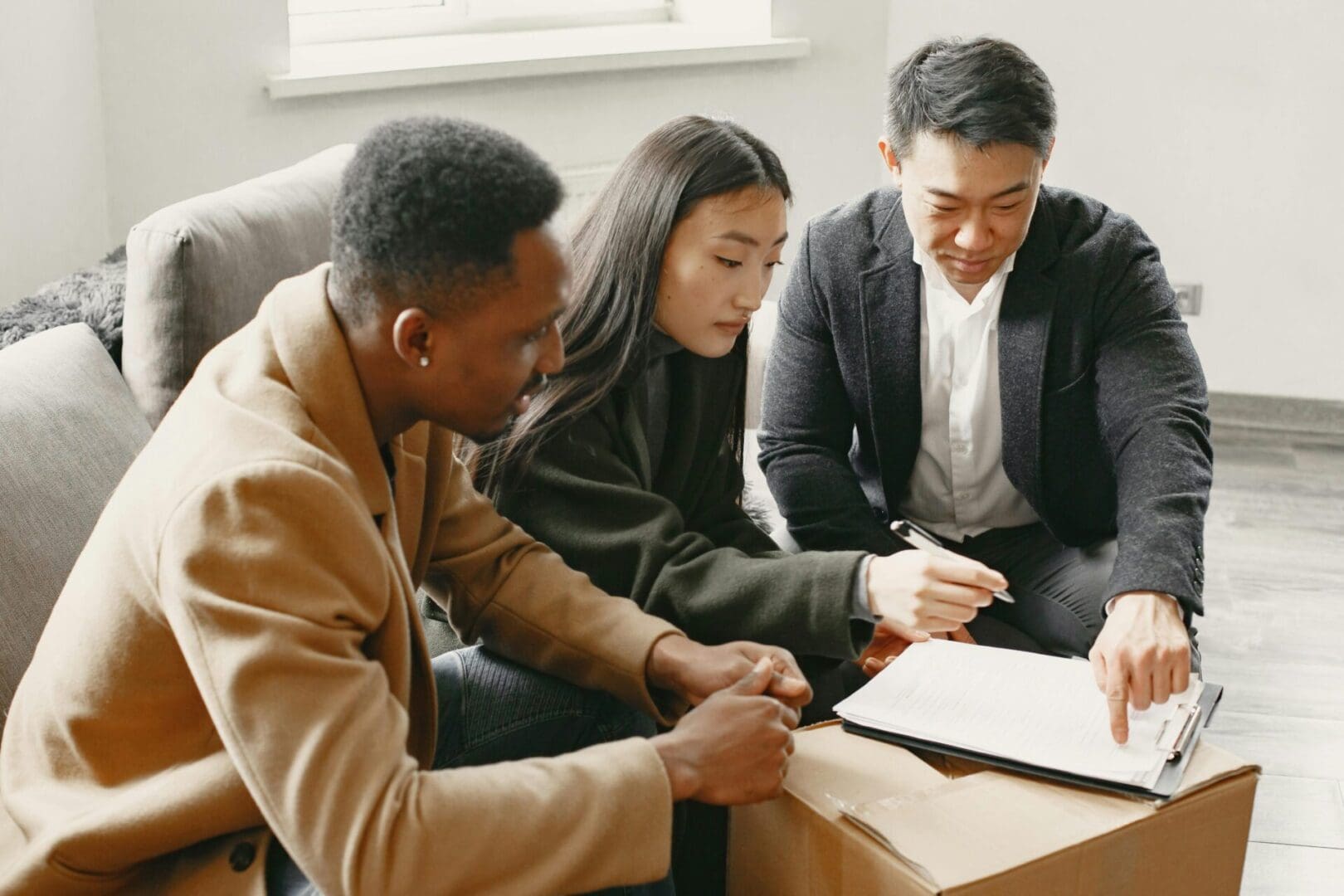 Three diverse professionals collaborating over documents in a bright office.