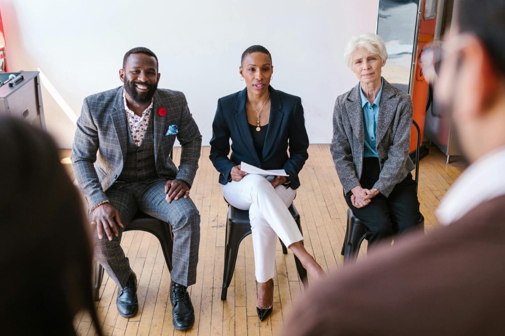 Three professionals engaged in a discussion in a modern office.
