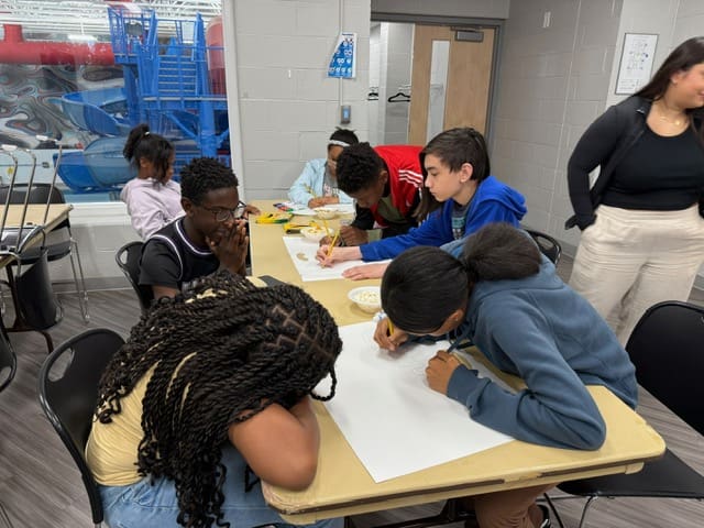 Children engaged in a classroom activity, writing and collaborating.