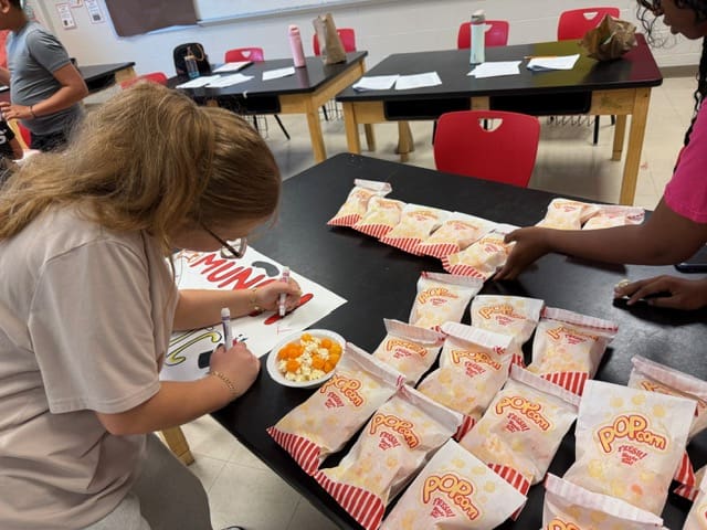Person arranging multiple Chick-fil-A meals on a table.