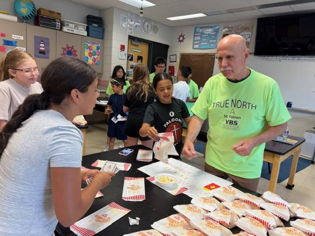 Volunteers distributing food packages in a community center.