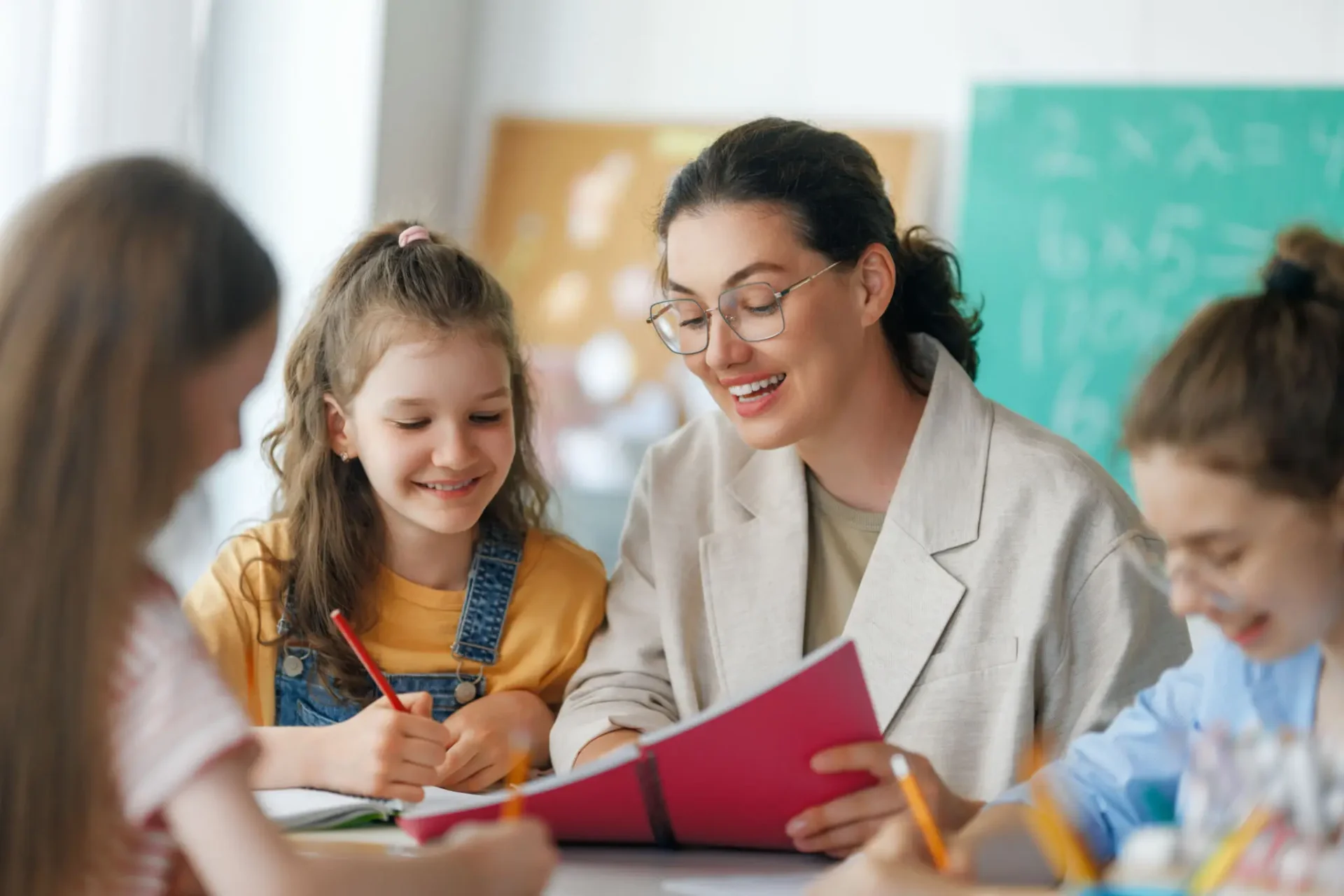 Teacher helping a young student with her work in class.
