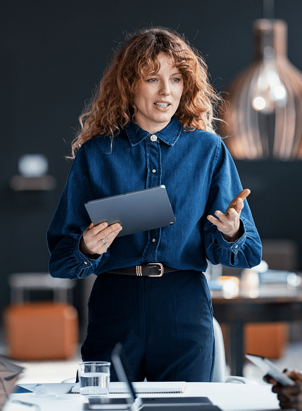 Woman giving a presentation, holding a digital tablet.