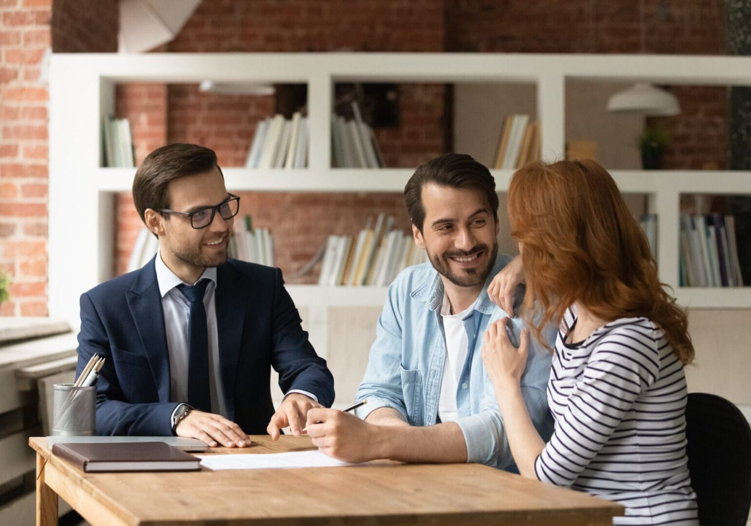 Three professionals having a friendly meeting in an office setting.